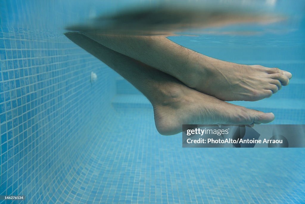 Man's legs in water, underwater view