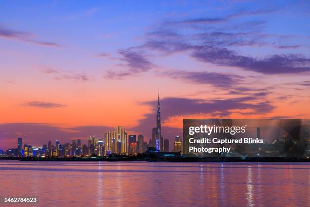 panoramic view of futuristic dubai city skyline during beautiful sunset across the lake - dubai marina stock pictures, royalty-free photos & images