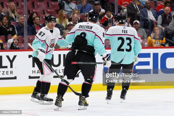 Sidney Crosby of the Pittsburgh Penguins celebrates with Alex Ovechkin of the Washington Capitals and Adam Fox of the New York Rangers after scoring...