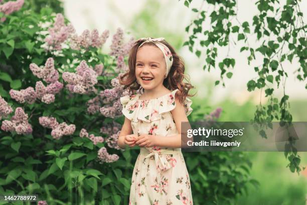 little girl in dress on flowers background. - toddler girl dress stockfoto's en -beelden