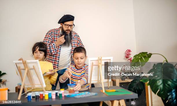 professeur d’art montrant aux enfants comment peindre - atelier enfant photos et images de collection