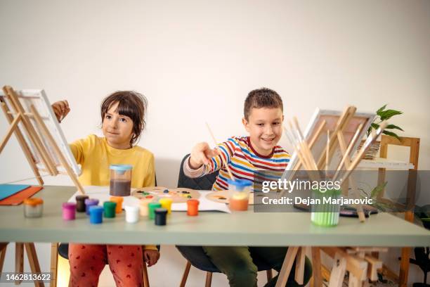 duas crianças se divertindo na aula de pintura - desenhar atividade - fotografias e filmes do acervo