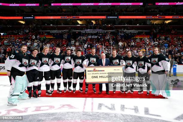 Deputy NHL Commissioner Bill Daly presents the Atlantic Division players of the Eastern Conference the winner's check of one million dollars after...