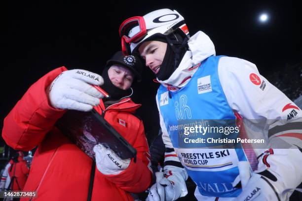 Mikael Kingsbury of Team Canada reviews video with a coach during the Dual Moguls Finals on day three of the Intermountain Healthcare Freestyle...