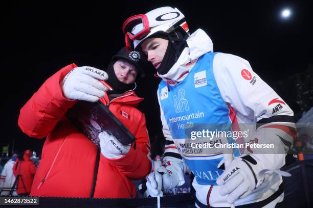 Mikael Kingsbury of Team Canada reviews video with a coach during the Men's Dual Moguls Finals on day three of the Intermountain Healthcare Freestyle...