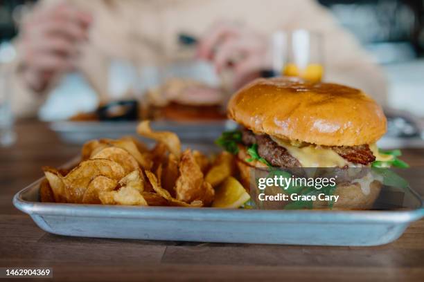 burger and chips on tray at restaurant - brioche stock pictures, royalty-free photos & images