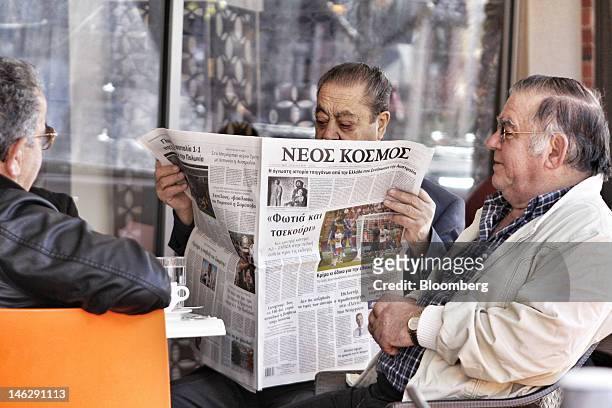 Man reads a Greek-language newspaper at a cafe in Oakleigh, a suburb of Melbourne, Australia, on Tuesday, June 12, 2012. Armed with patriotism and...