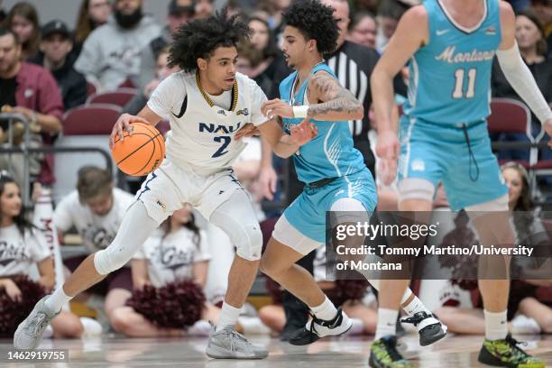 Xavier Fuller of the Northern Arizona Lumberjacks dribbles against Brandon Whitney of the Montana Grizzlies at Dahlberg Arena on February 04, 2023 in...