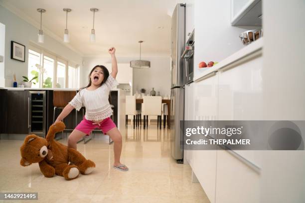 little girl fighting a teddy bear - girls wrestling stockfoto's en -beelden