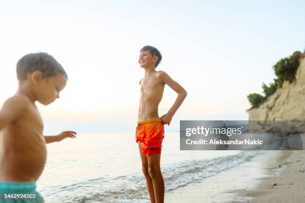 junge jungs haben spaß am strand - boy in swimwear stock-fotos und bilder