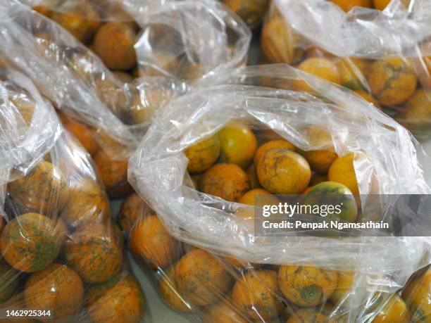 orange fruit in clear plastic bag background - sack ストックフォトと画像