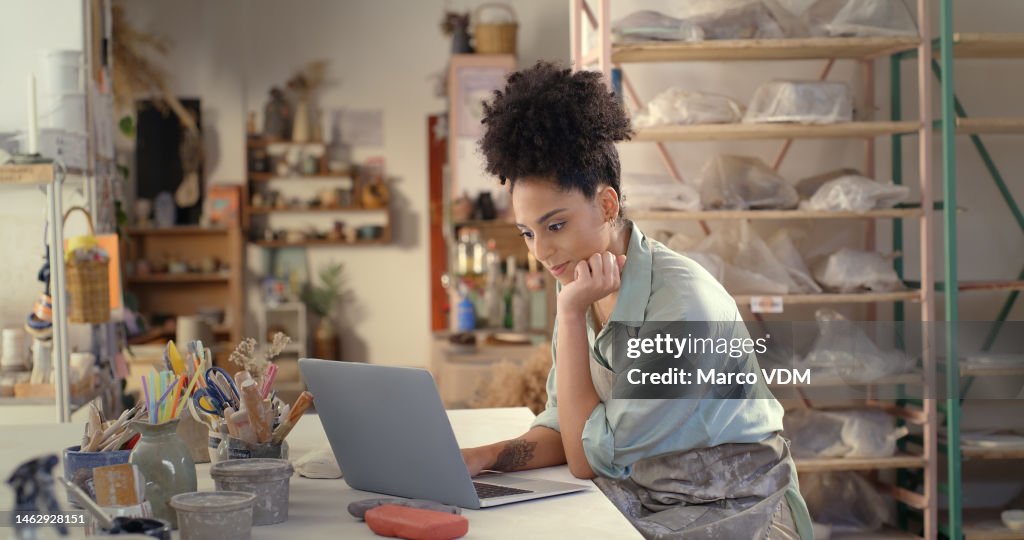 Creative black woman, laptop and thinking in small business for planning, strategy or idea for startup. African American female store owner working on computer for online marketing in studio workshop