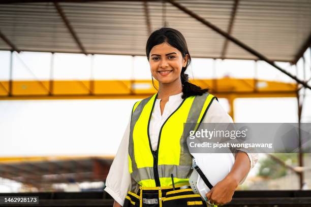portrait, young indian engineer smiling standing at a construction site. - confident young man at work stock pictures, royalty-free photos & images