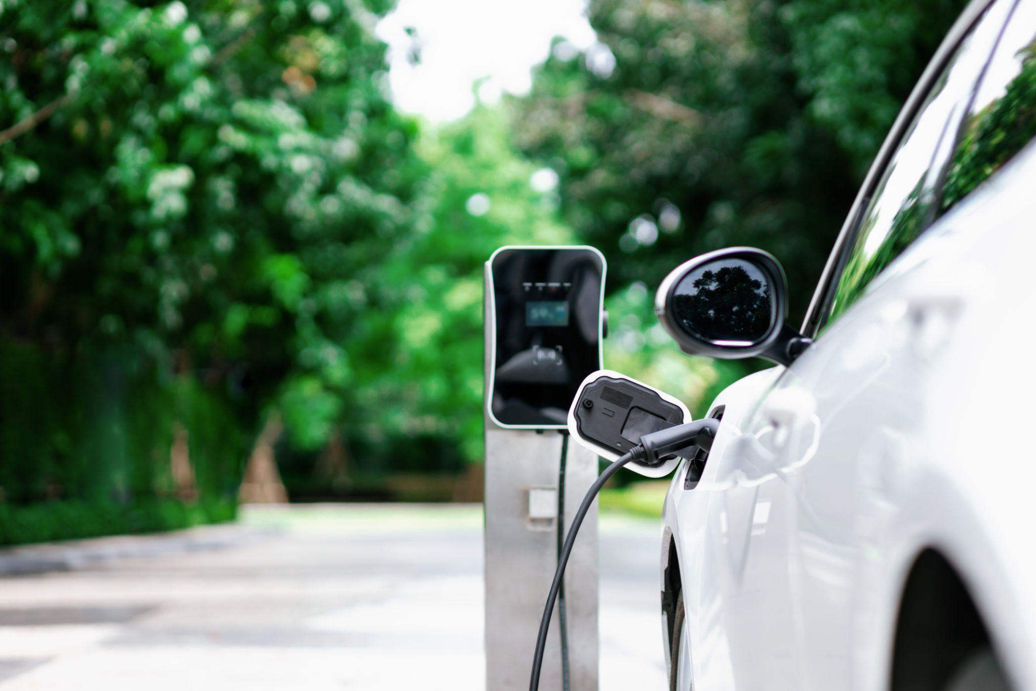 Focus closeup EV car and charger with blur background for progressive concept Focus closeup EV car and charger with blur background for progressive concept