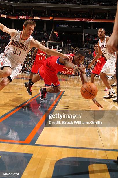 Jodie Meeks of the Philadelphia 76ers and Matt Carroll of the Charlotte Bobcats reach for possession during the game at the Time Warner Cable Arena...