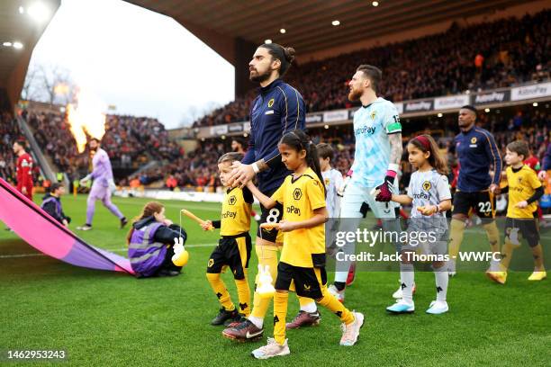 Ruben Neves of Wolverhampton Wanderers walks out with mascots holding Rabbit Lanterns in celebration of the Lantern Festival ahead of the Premier...