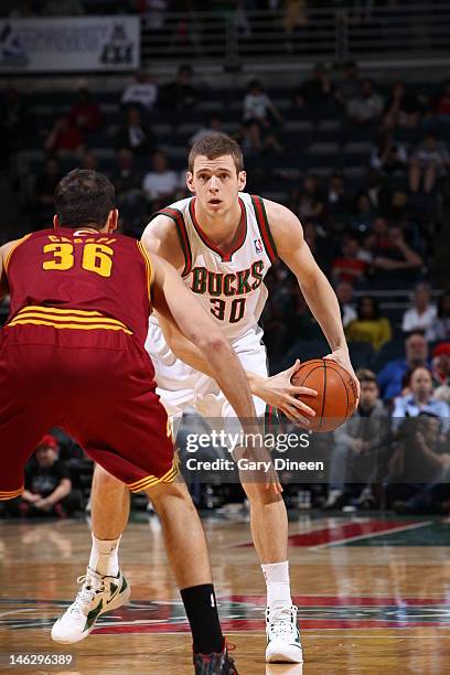 Jon Leuer of the Milwaukee Bucks handles the ball against Omri Casspi of the Cleveland Cavaliers on March 14, 2012 at the Bradley Center in...