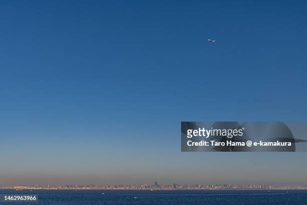 the airplane flying over the sea in tokyo of japan - ota ward stock-fotos und bilder