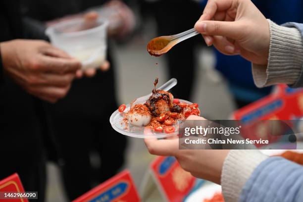 Tourist prepares to eat Tangyuan with spicy dipping sauce at a scenic area ahead of the Lantern Festival on February 4, 2023 in Chongqing, China. The...
