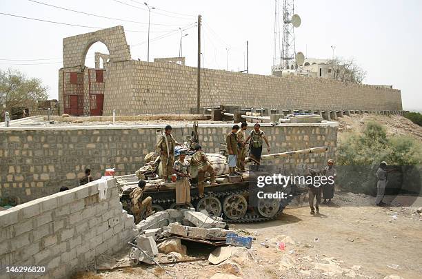 Yemeni soldiers and local tribes men gather around a tank on June 13 after the army seized the Al-Qaeda strongholds of Jaar and the provincial...