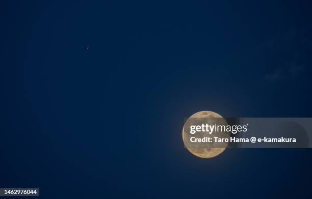 the airplane flying over moon in kanagawa of japan - kamakura city stock pictures, royalty-free photos & images