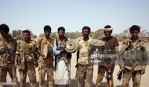 Yemeni soldiers pose with munition they found on June 13 after the army seized the Al-Qaeda strongholds of Jaar and the provincial capital Zinjibar...