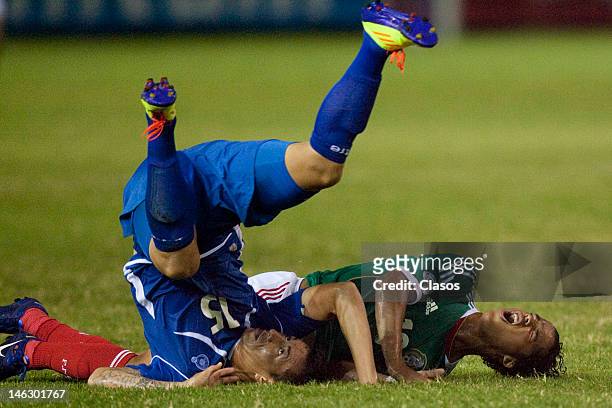Israel Pacheco of El Salvador and Giovani Dos Santos of Mexico fight for a ball during a match between El Salvador and Mexico at Cuscatlan Staduim,...