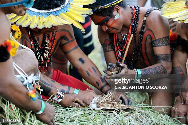 Brazilian Kayapo and Xerente indians prepare to set fire on the Holy Pyre using a traditional method during the Kari-Oca opening ceremony in the...