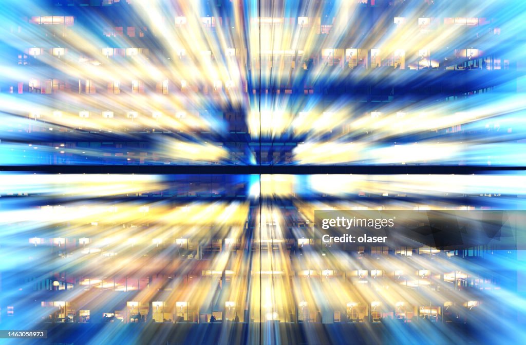 Zoom blurred office windows by blue hour / night.