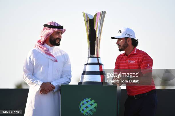 Abraham Ancer of Mexico receives the trophy from Noah Alireza, CEO of Golf Saudi, after winning the PIF Saudi International at Royal Greens Golf &...