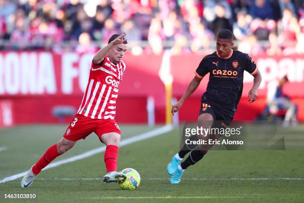 Miguel Gutierrez of Girona FC battles for possession with Lino of Valencia CF during the LaLiga Santander match between Girona FC and Valencia CF at...