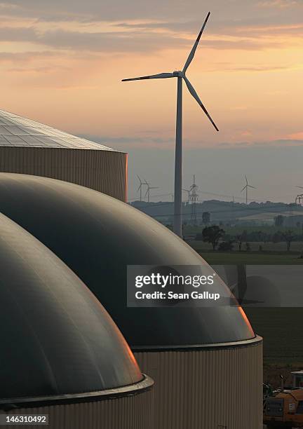 Wind turbine spins behind a new biogas plant in Lower Saxony on June 12, 2012 near Ebendorf, Germany. The plant processes natural waste from local...