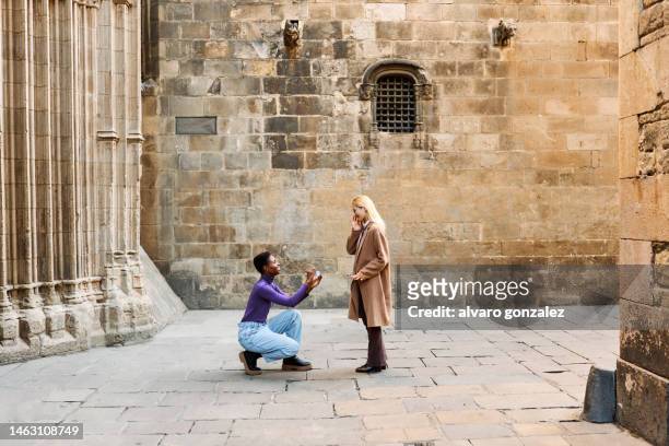 woman asking her lesbian partner to marry her outdoors - gay marriage stockfoto's en -beelden