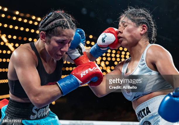 Amanda Serrano punches Erika Cruz during their fight for Serrano, WBC, WBO and IBF featherweight titles and Cruz's WBA featherweight title at The...