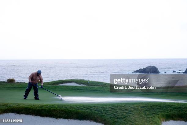Grounds crew attempt to dry the green on the fifth hole during a continuation of the third round of the AT&T Pebble Beach Pro-Am at Pebble Beach Golf...