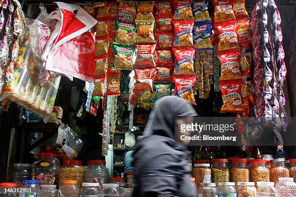 Woman walks past a grocery store in the Dharavi slum area of Mumbai, India, on Tuesday, June 5, 2012. More than three-quarters of the 1.2 billion...