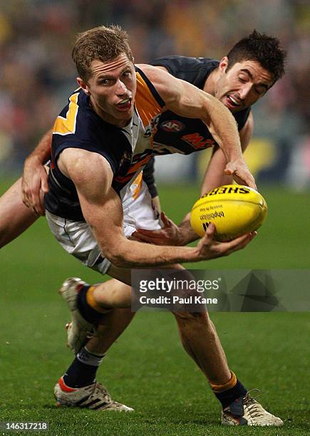 Kade Simpson of the Blues tackles Adam Selwood of the Eagles during the round 12 AFL match between the West Coast Eagles and the Carlton Blues at...