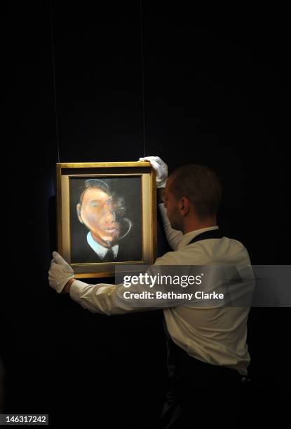 Curator adjusts 'Self Portrait' by Francis Bacon is put on display at Sotheby's on June 14, 2012 in London, England. This piece is part of the...