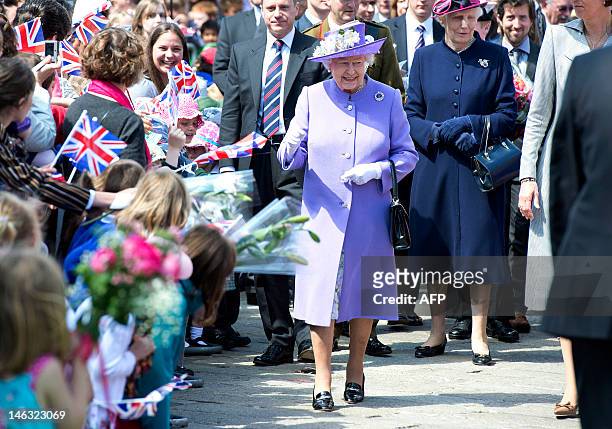 Britain's Queen Elizabeth II greets well-wishers as she visits the market square in the town of Hitchin in Hertfordshire on June 14, 2012 as she...
