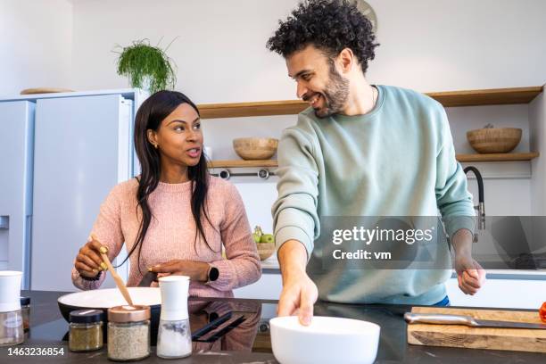 man and woman cooking and talking in a home kitchen - north african ethnicity stock pictures, royalty-free photos & images