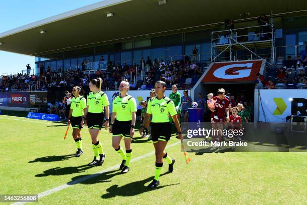 Referees lead the teams out during the round 13 A-League Women's match between Adelaide United and Brisbane Roar at ServiceFM Stadium, on February 05...