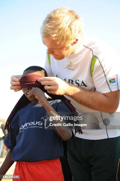 Schalk Burger puts a blind fold on Xolani Vilakazi during the Laureus Soweto Schools Rugby Project visit at Tswelelang Primary School on June 14,...