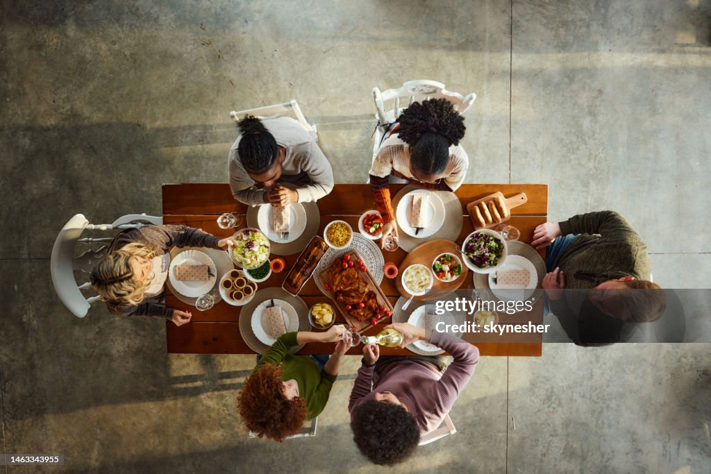 Above view of young friends having lunch at dining table.