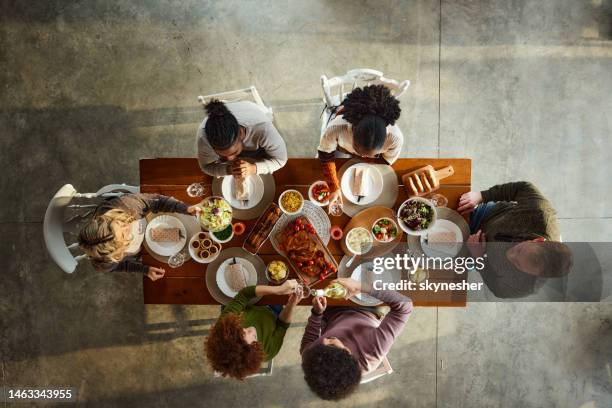 above view of young friends having lunch at dining table. - vista de cima para baixo mesa imagens e fotografias de stock