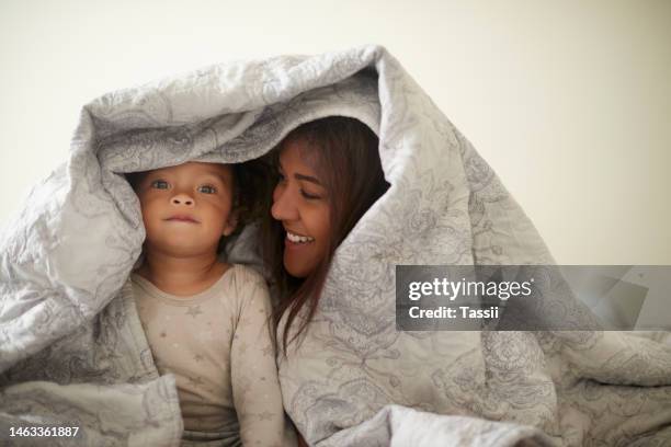 mother, baby and blanket fort in bed, happy and bonding while playing, relax and having fun in their home. love, mom and girl toddler in a bedroom, waking up and resting, playful and content together - blanket fort stock pictures, royalty-free photos & images