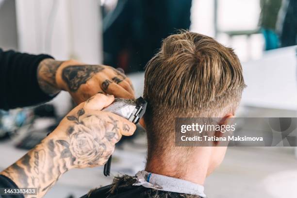 portrait of a young graying man in a barbershop. beauty and care for men. - electric razor stock pictures, royalty-free photos & images