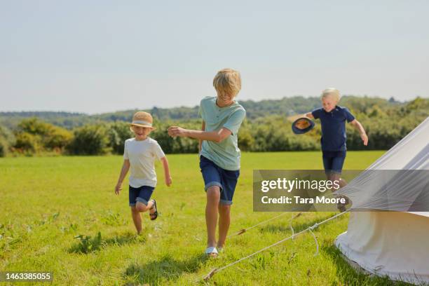 children playing next to bell tent - bell boy stock-fotos und bilder