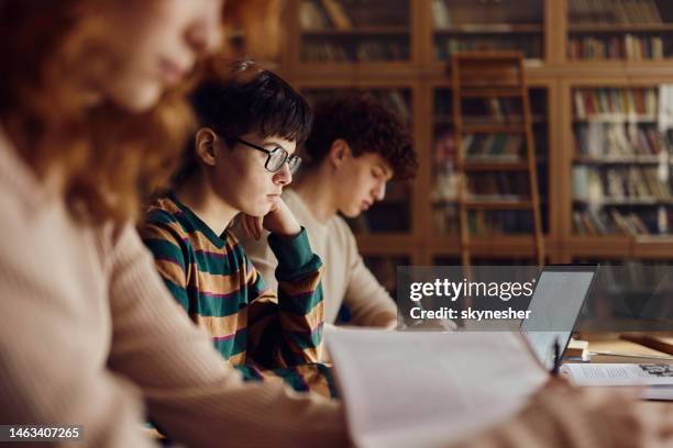 group of high school students studying in library. - secondary school reading stock pictures, royalty-free photos & images