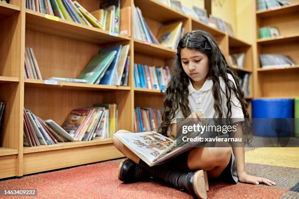 junge hispanische studentin liest graphic novel - comic book stock-fotos und bilder