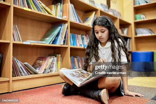 joven estudiante hispano leyendo novela gráfica - comic book fotografías e imágenes de stock